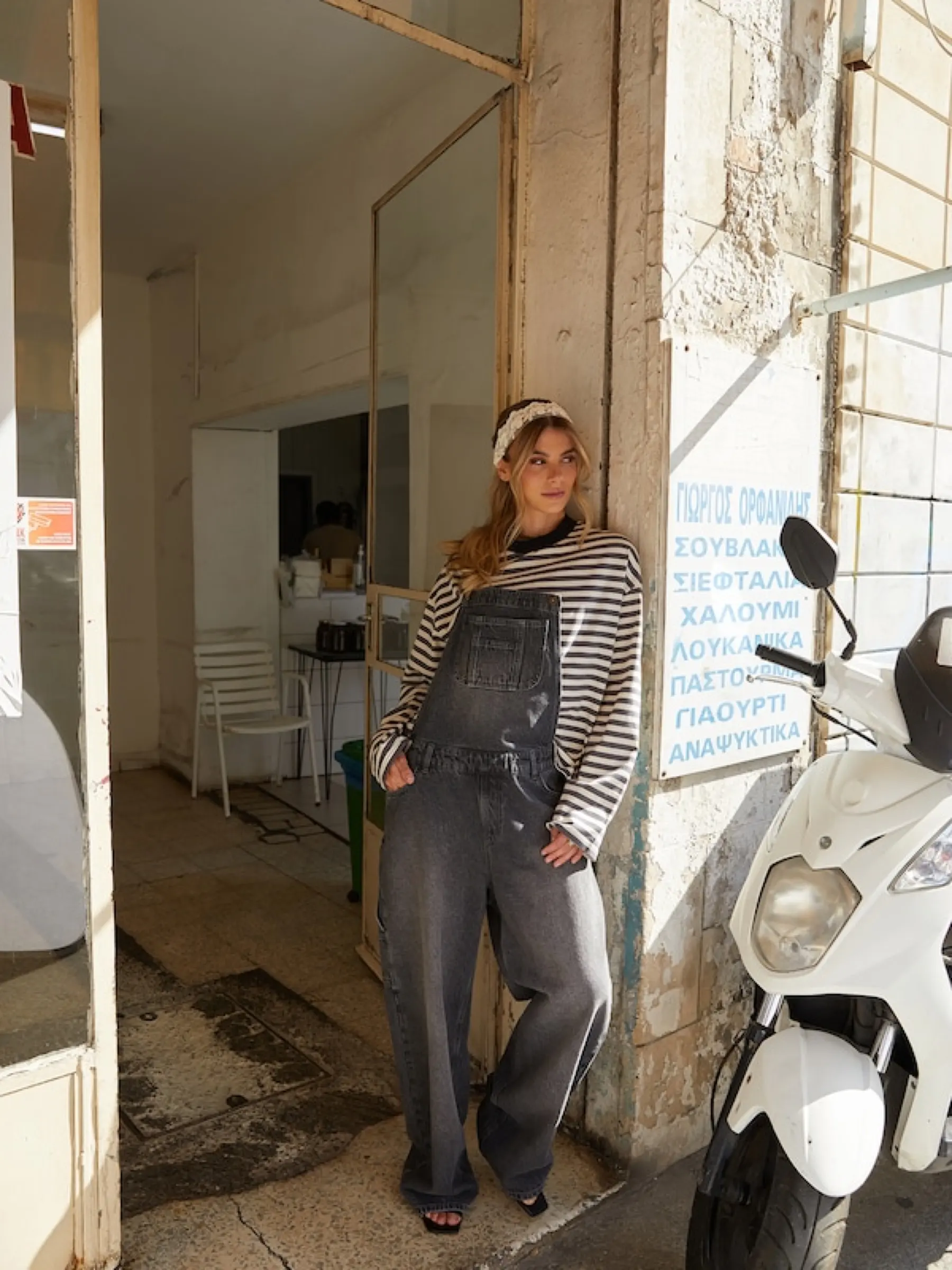 Romina Palm i jeansoveraller i en dörröppning
